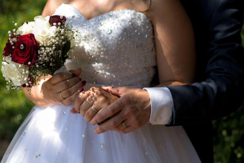 reportage de mariage, un bouquet, les mains des mariées et leurs bagues, photographe en normandie pres de caen